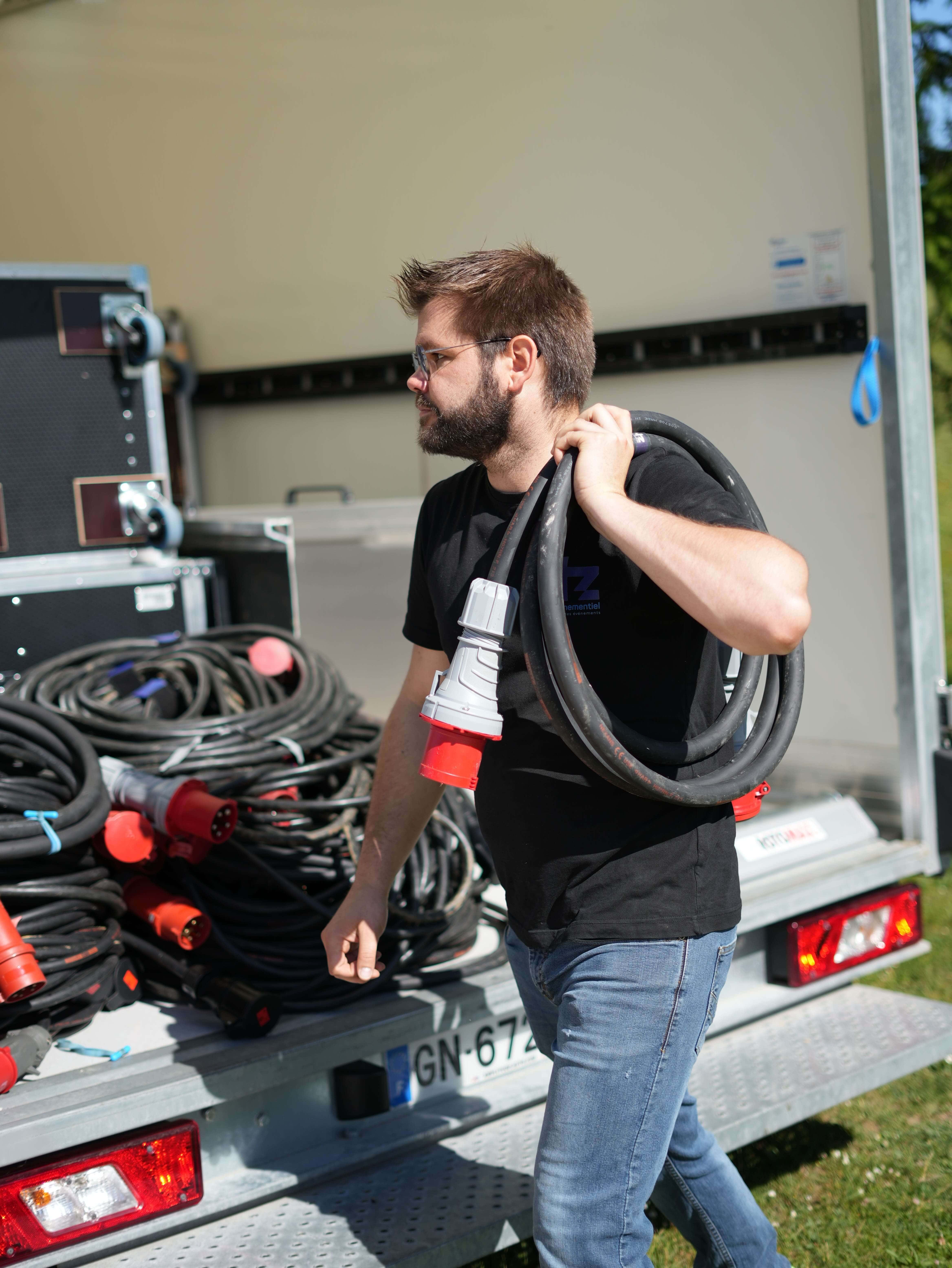 Technicien exécutant une prestation de distribution électrique avec rallonges 32A.