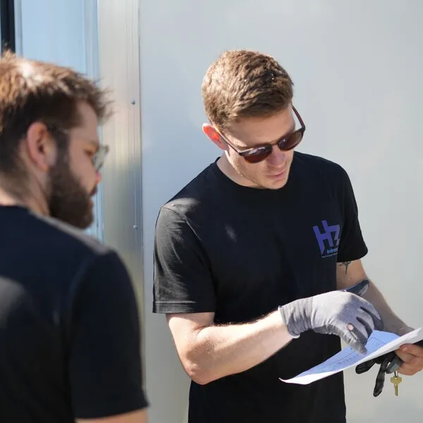 Techniciens se référant à un plan de distribution électrique avant l'implantation d'un événement.