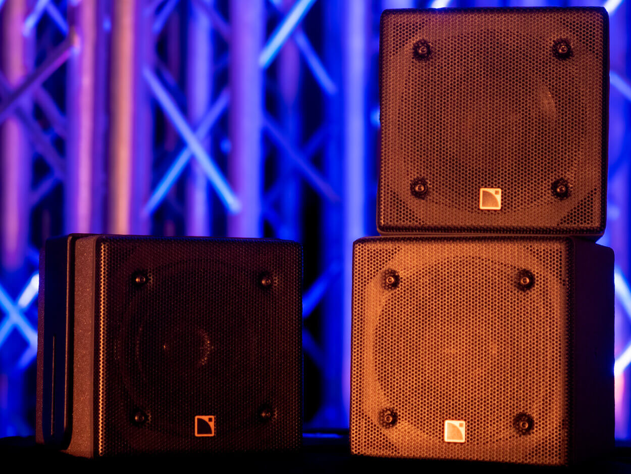 Présentation d'enceintes L-Acoustics 5XT sur fond coloré.