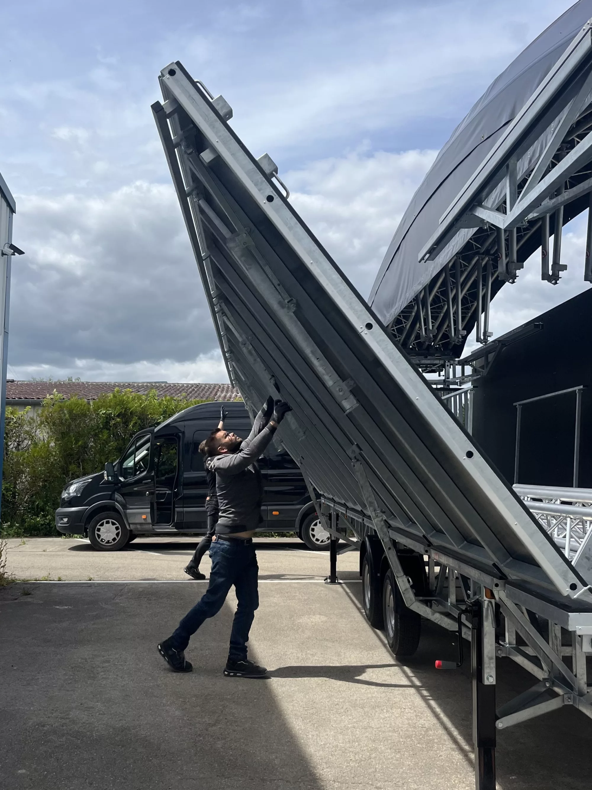 Plateau de 55m² d'une scène mobile dôme en train d'être installé par un technicien